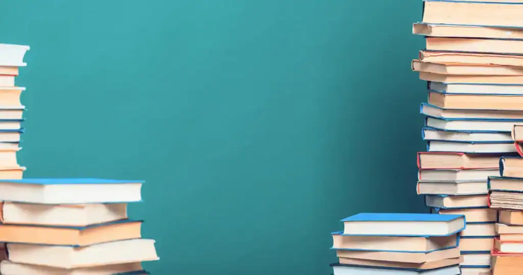 Stacks of books with colorful covers and spines—featuring some of the best gut health books—are arranged on the left and right sides of the image, leaving empty space in the center against a teal background.