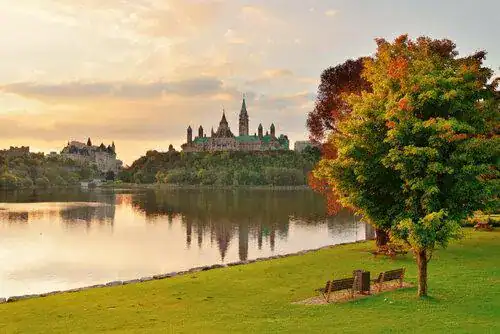 Saskatchewan's riverside view of golden-lit towers across the water, representing In Good Nutrition's commitment to empowering Saskatchewanians with personalized dietitian support.