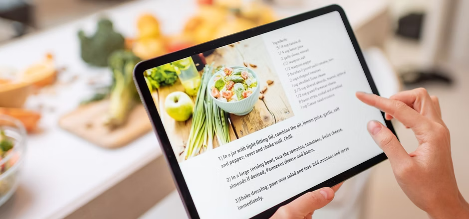Women cooking viewing free meal plan recipe on ipad