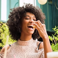 young women with a healthy relationship with food eating a frie and enjoying her food